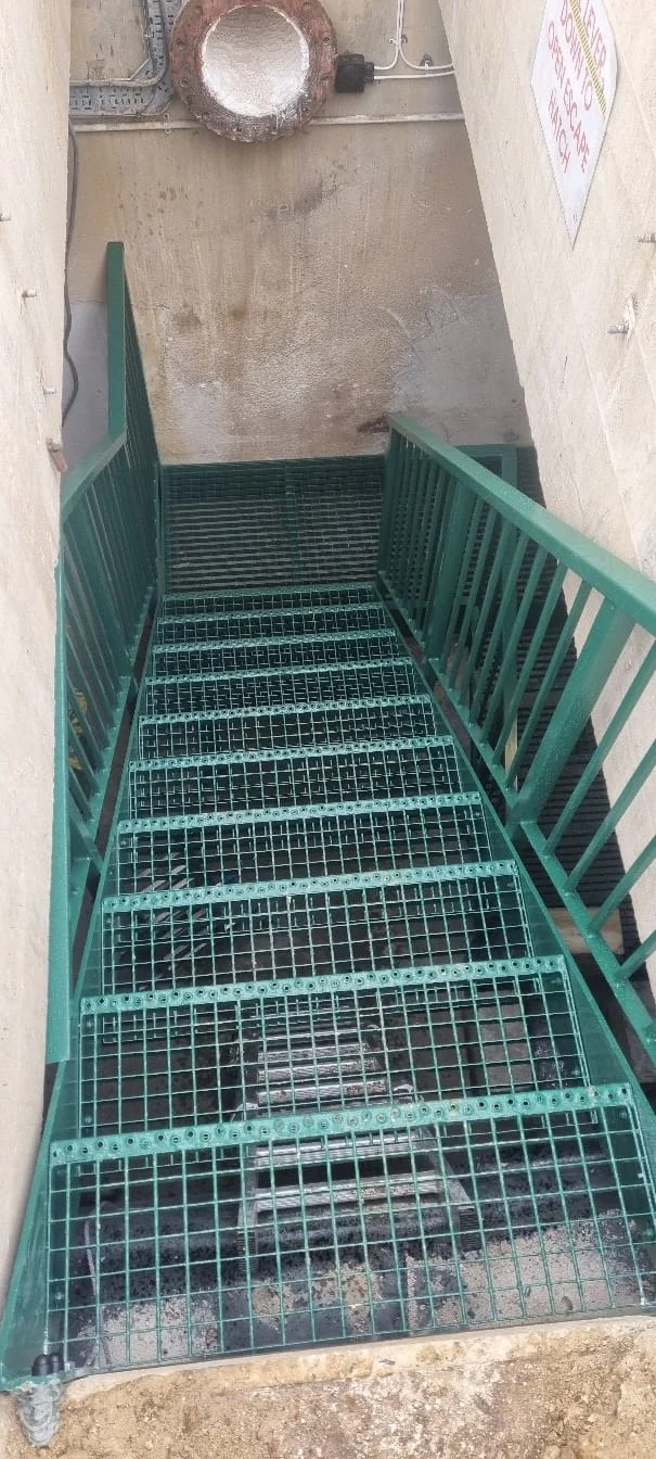 Green powder-coated steel fire escape with safety handrails